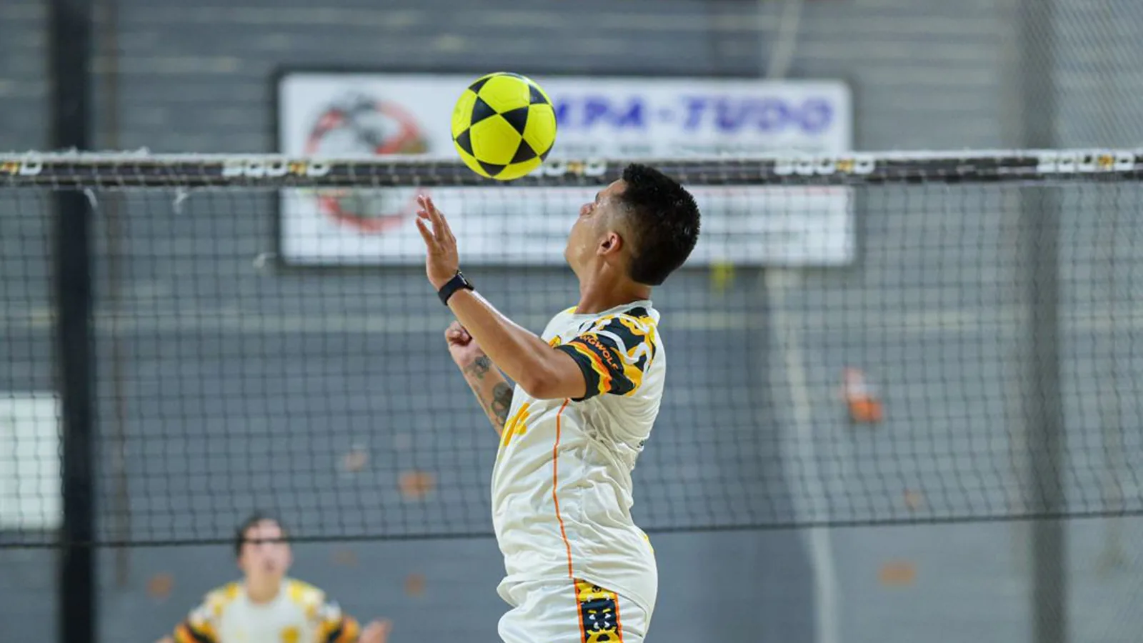 Atleta do CCA prepara um saque durante a operação de uma etapa de futevôlei.