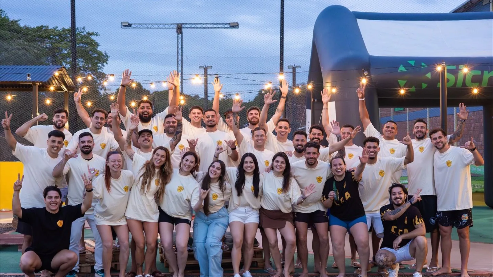 Participantes e equipe do CCA reunidos após uma etapa do campeonato em uma arena esportiva.